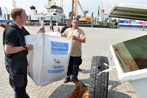  Fischer aus Norddeich in Niedersachsen entleerendie gefischten Abfälle im Projekt-Container 