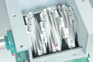  Close up of screen classifying cutter with 38 cm long, 28 cm diameter rotor illustrates helical array of staggered, carbide tipped holders that continuously shear material against twin, stationary bed knives 