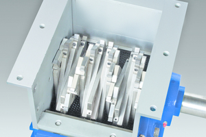  Cutter tips attached to a helical array of staggered holders continuously shear oversize materials against twin, stationary bed knives 