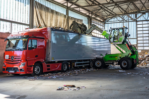  The SENNEBOGEN 340 G effortlessly loads waste into a truck with its telescopic arm 